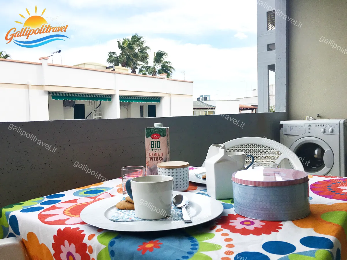 Balcone del Bilocale La Vela con colazione e tovaglia fiorata a Baia Verde