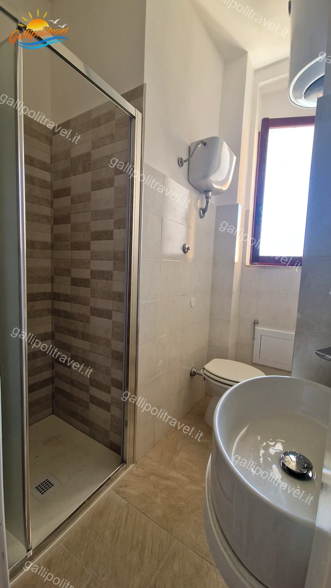 Première salle de bain avec carrelage moderne de l'appartement de quatre pièces Via dei Tigli, Baia Verde