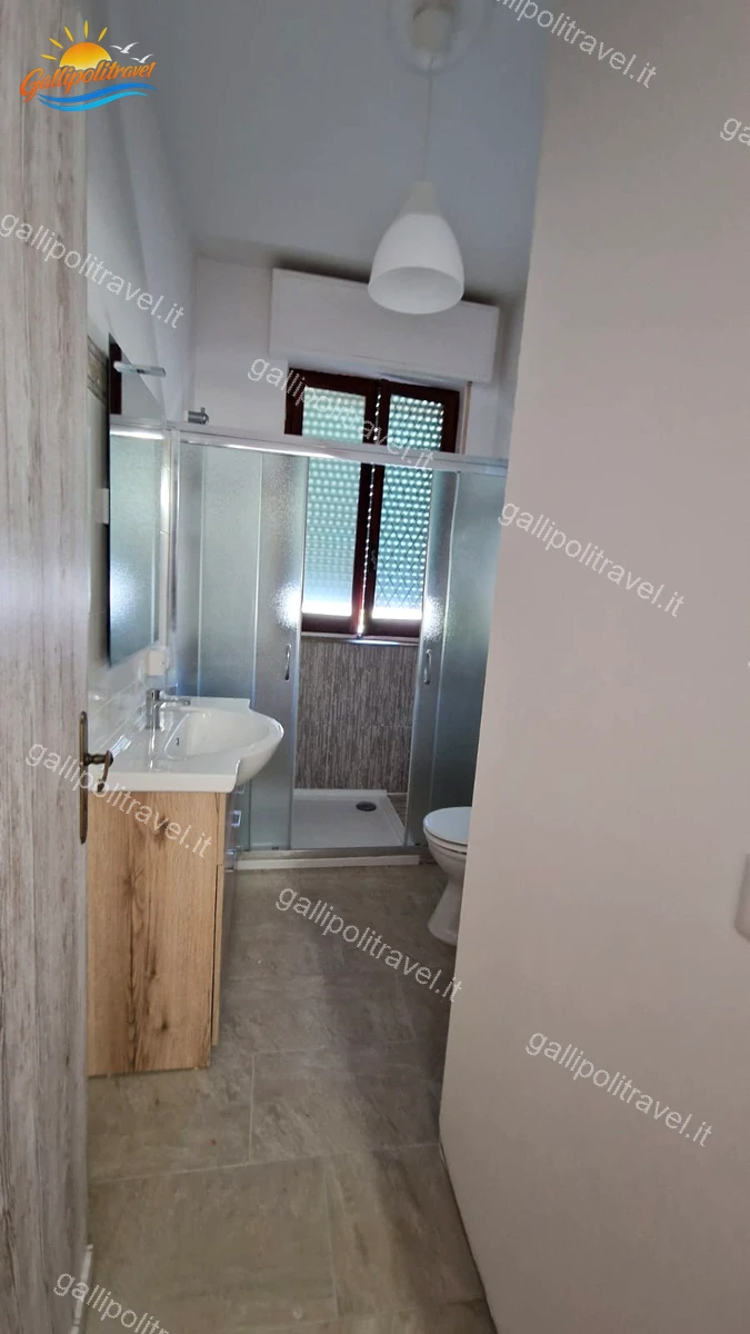 Deuxième salle de bain avec meubles en bois et douche, appartement de quatre pièces Via dei Tigli Gallipoli