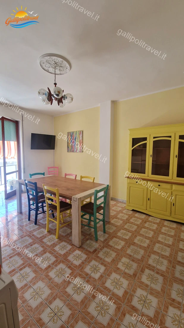 Salon avec table et chaises multicolores de l'appartement de quatre pièces Via dei Tigli, Gallipoli