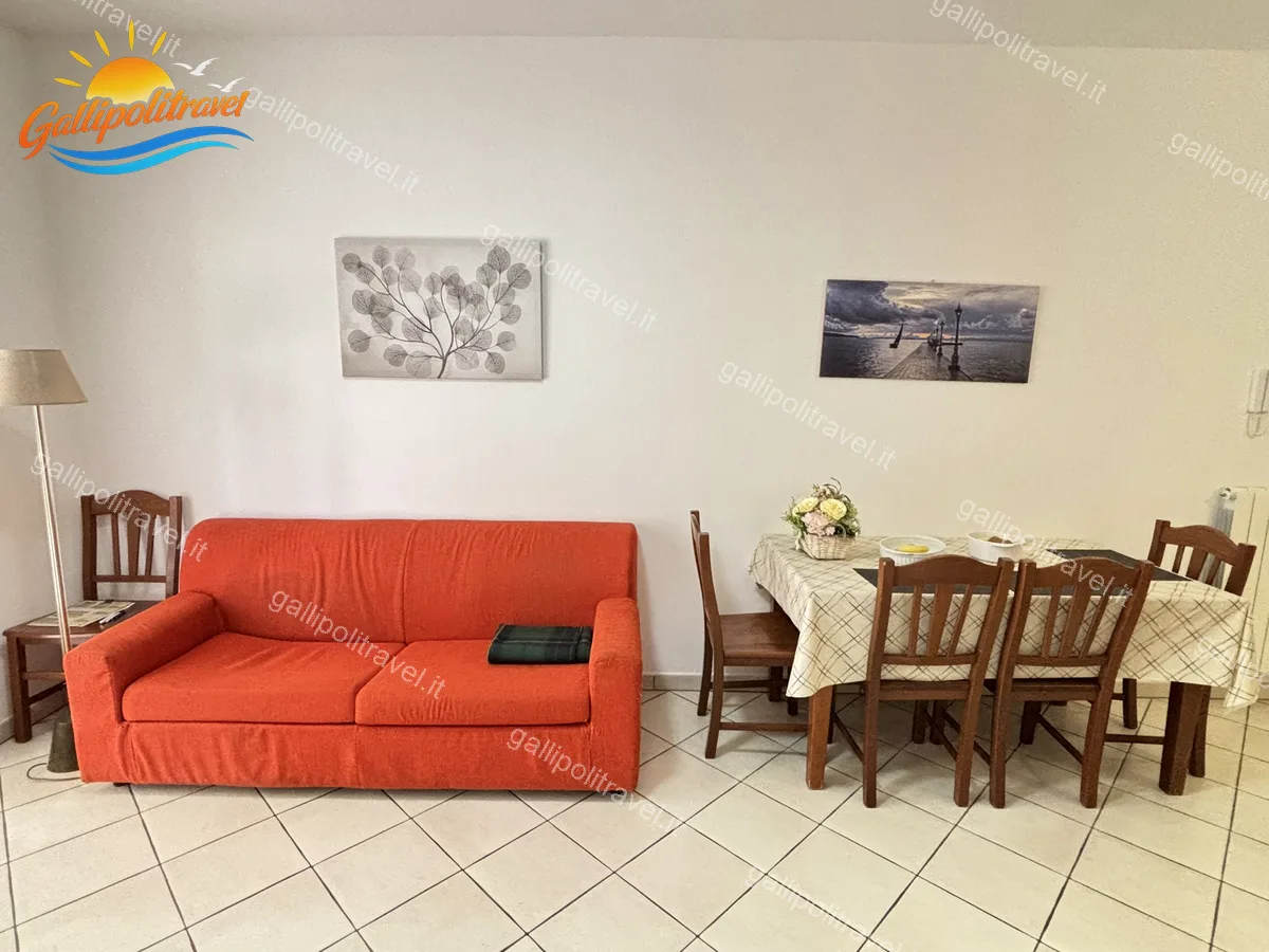 Coin séjour avec table à manger et canapé de l'appartement trois pièces B2/3, Rosa Virginia Gallipoli