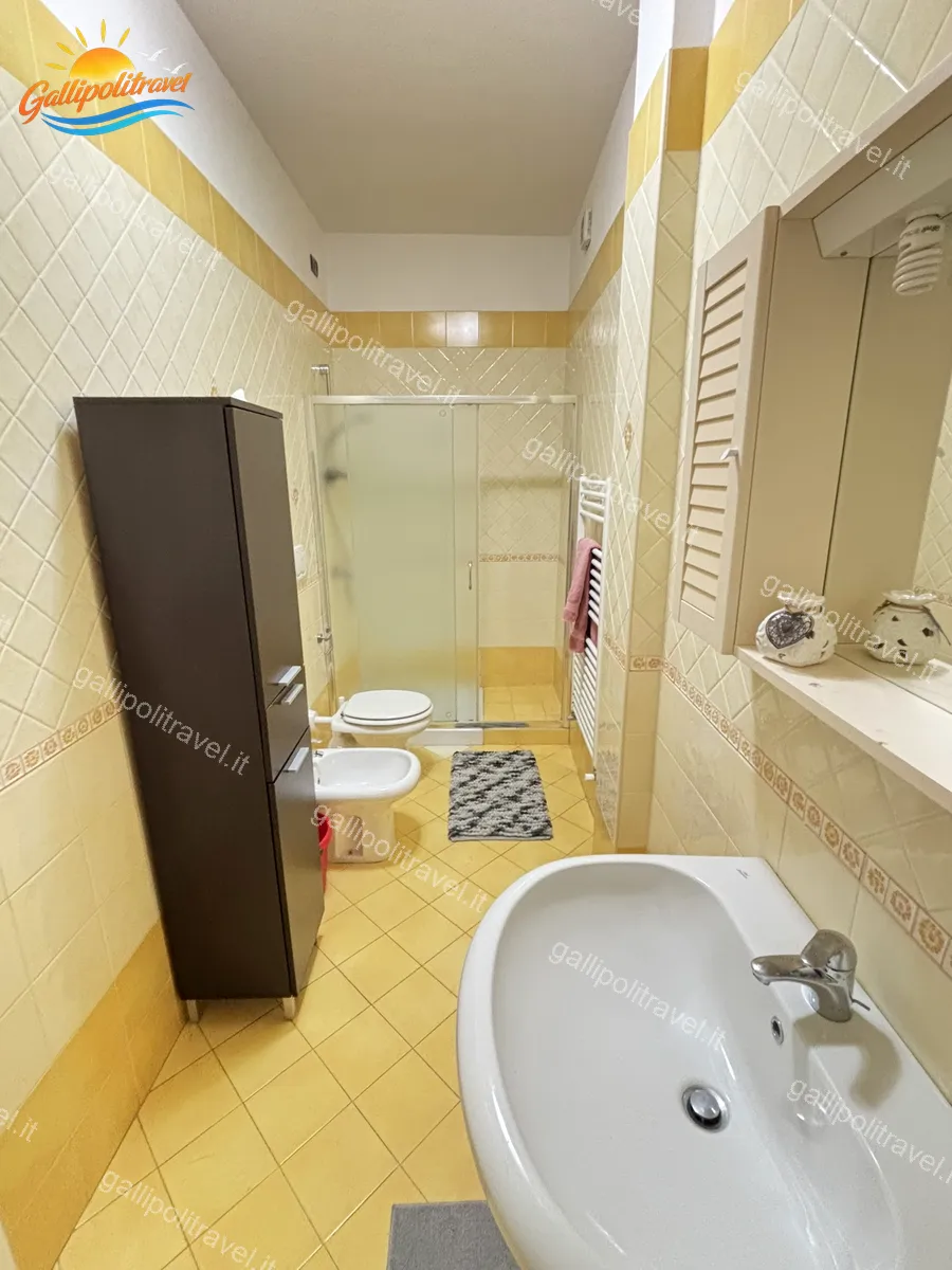 Bagno con piastrelle gialle e doccia del Trilocale B2/4 Gallipoli