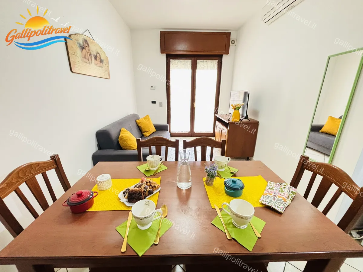 Soggiorno con tavolo pranzo e divano grigio del Trilocale B2/4 Gallipoli
