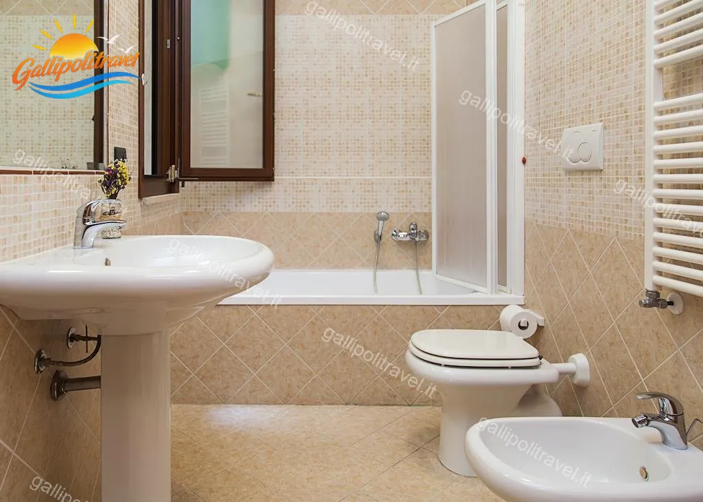 Badezimmer mit beigem Mosaik, Badewanne und Handtuchwärmer der Dreizimmerwohnung F1/1, Rosa Virginia