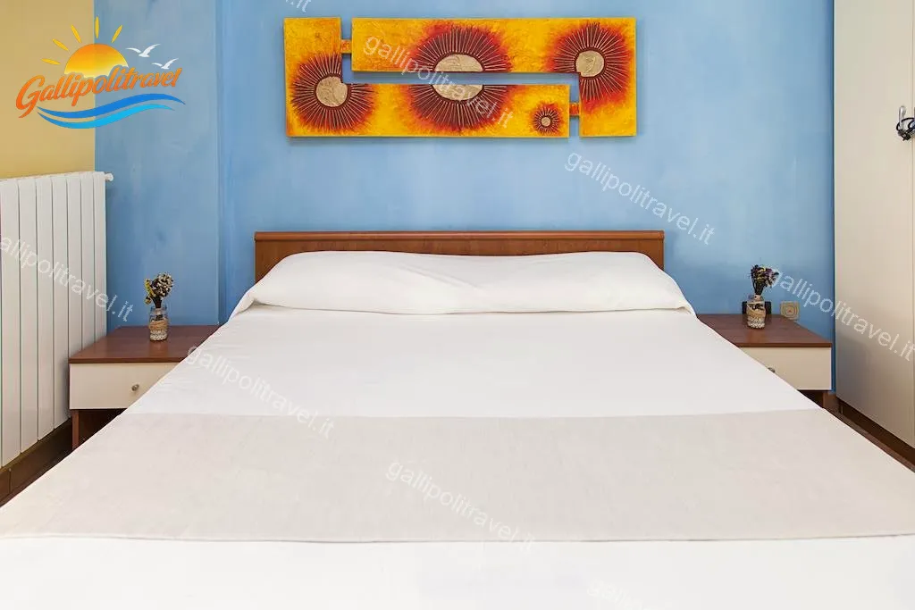 Doppelzimmer mit blauer Wand und Gemälden der Sonne, Dreizimmerwohnung F1/1 Gallipoli