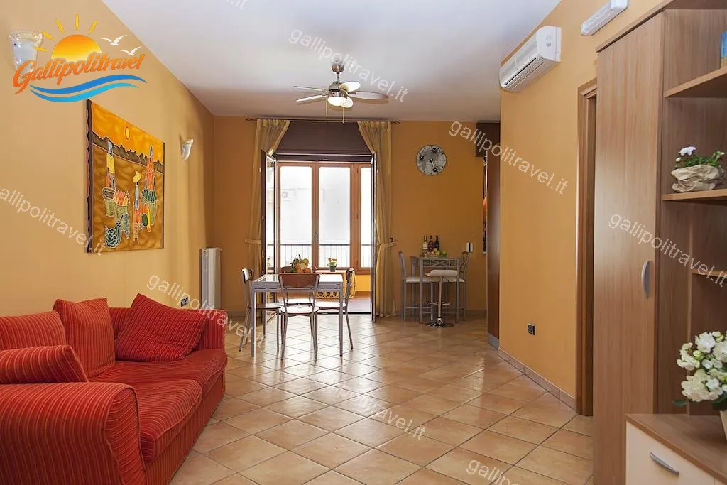Großes Wohnzimmer mit rotem Sofa und Ventilator der Dreizimmerwohnung F1/1, Gallipoli