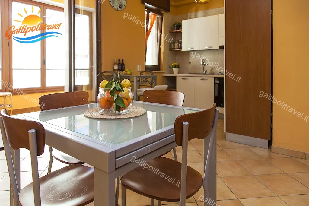 Essbereich mit Glastisch und Zitrusfrüchten der Dreizimmerwohnung F1/1, Rosa Virginia