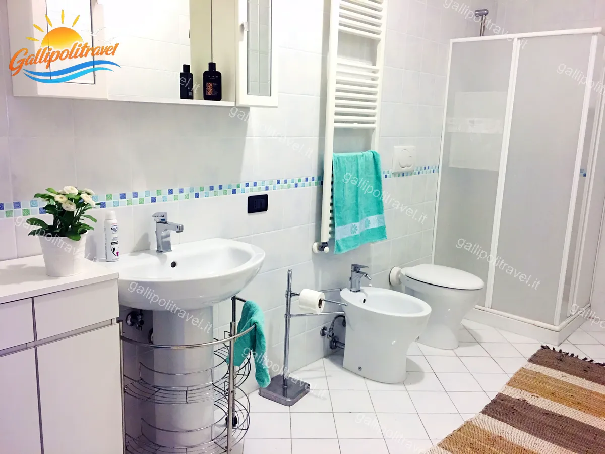 Zweites weißes Badezimmer mit türkisfarbenem Handtuch und Dusche, Dreizimmerwohnung H2/2 Gallipoli