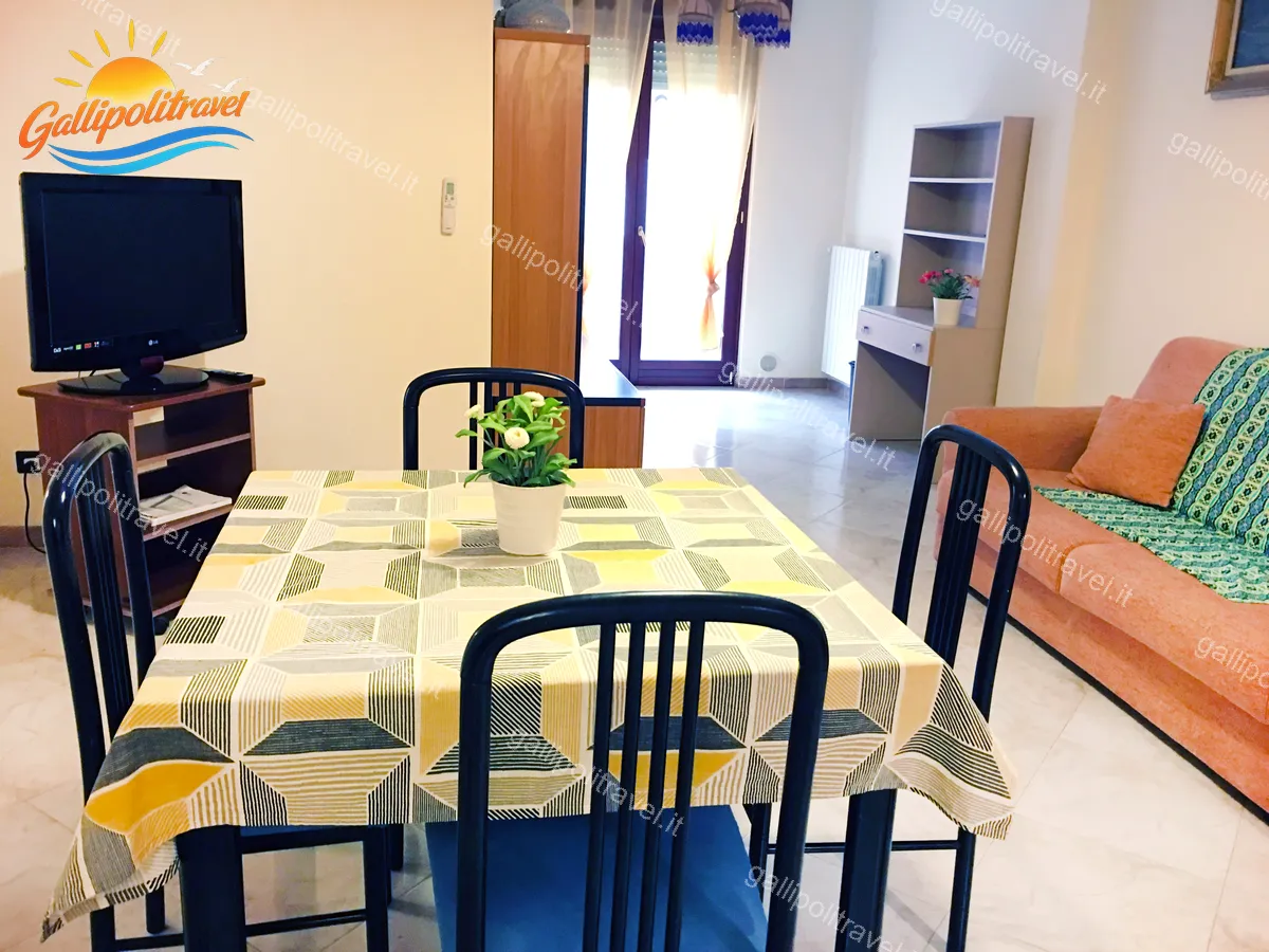 Wohnzimmer mit gelber Tischdecke und Sofa der Dreizimmerwohnung H2/2, Gallipoli