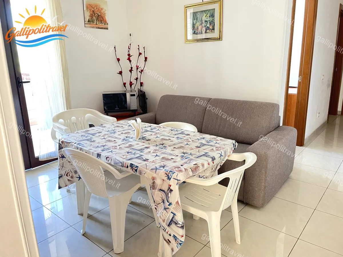 Dining area with sofa of the three-room apartment Orange, Residenza Marina Baia Verde Gallipoli