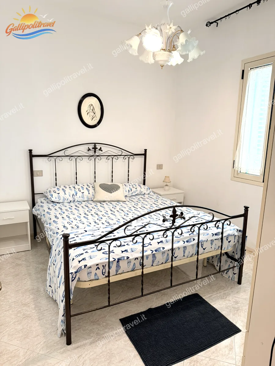 Camera matrimoniale con letto in ferro del Trilocale Robinia, Baia Verde