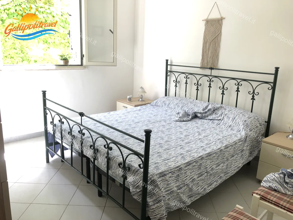 Chambre avec lit en fer forgé de l'appartement trois pièces Tamerici 02, Baia Verde Gallipoli