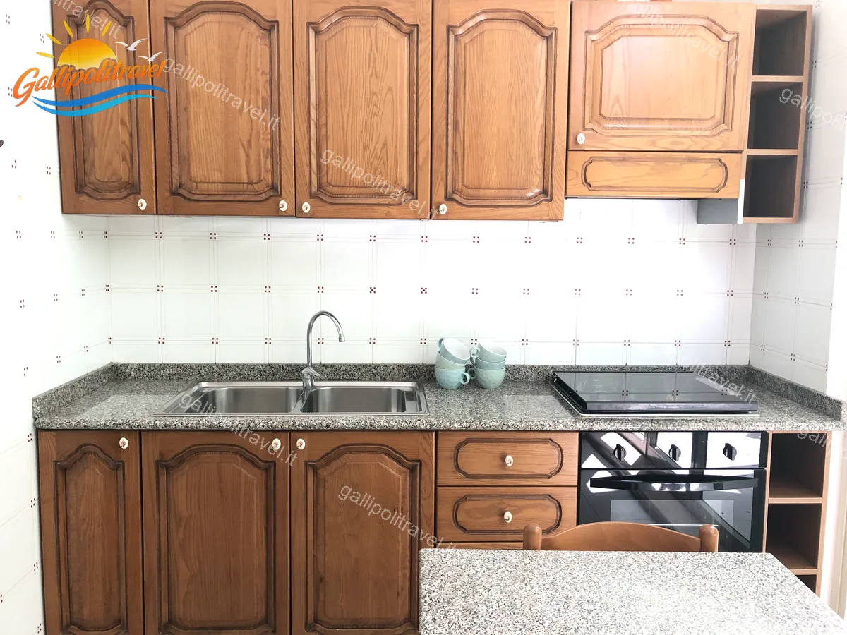 Cuisine en bois avec plaque de cuisson de l'appartement trois pièces Tamerici 02, Baia Verde