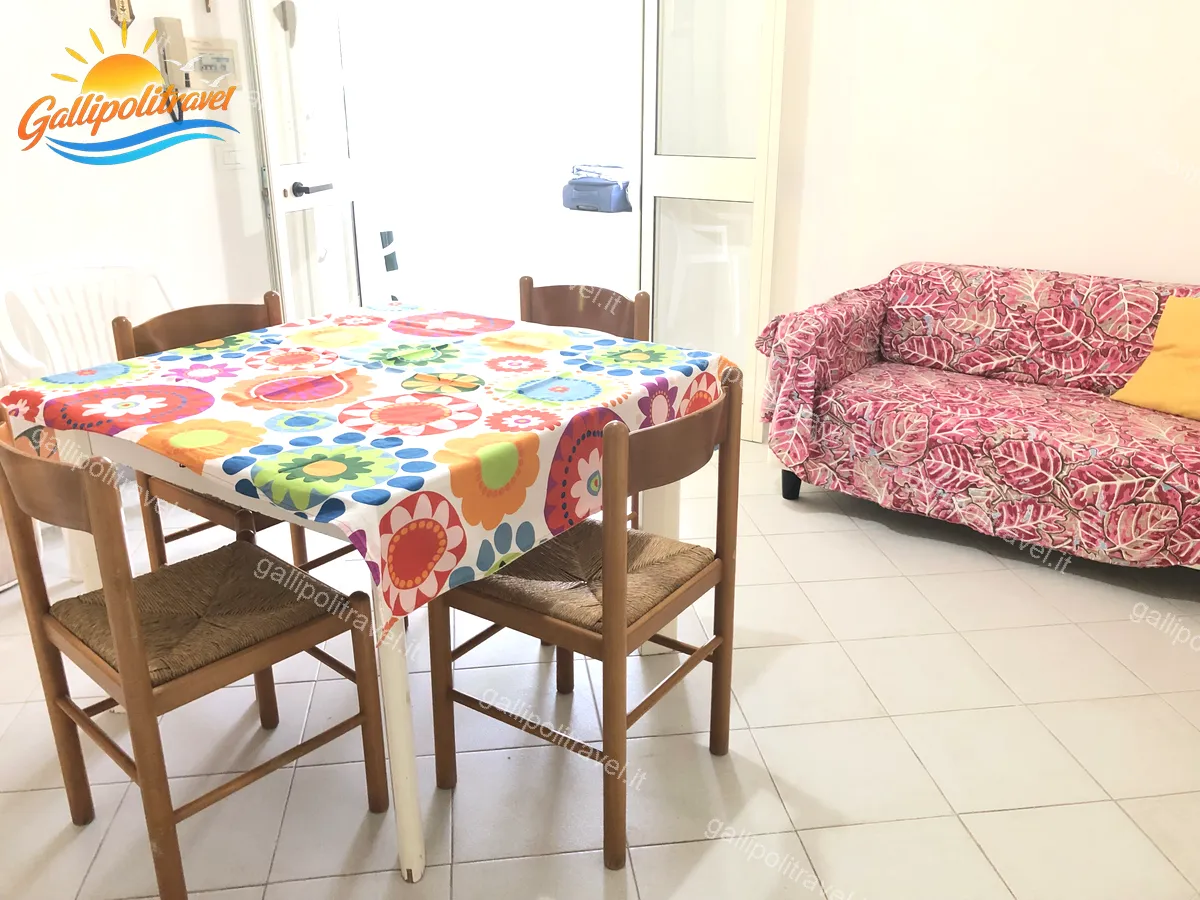 Séjour avec table et nappe colorée de l'appartement trois pièces Tamerici 02, Baia Verde Gallipoli