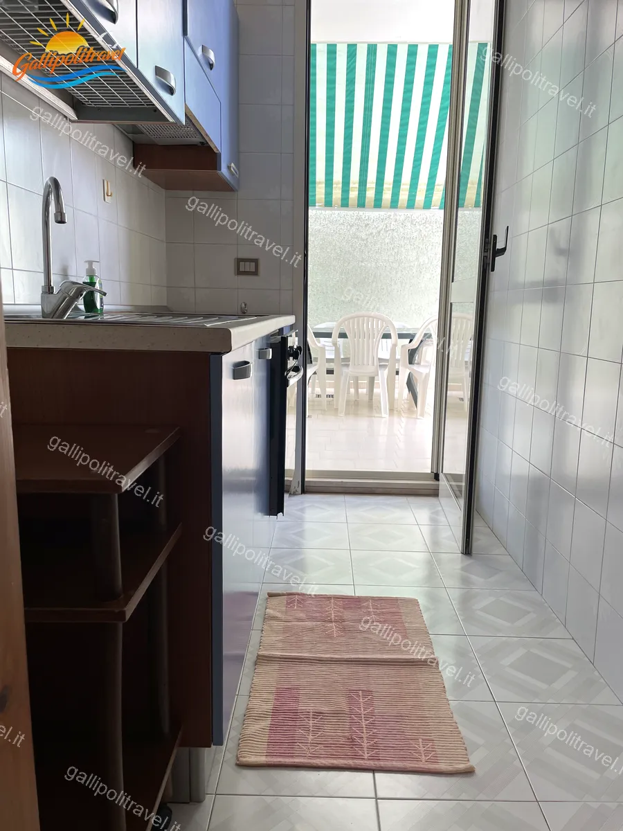 Cuisine ouverte avec accès au patio de l'appartement trois pièces Tamerici 03, Baia Verde Gallipoli