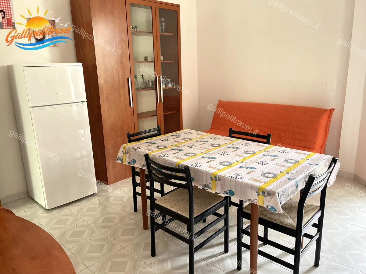 Séjour avec canapé orange de l'appartement trois pièces Tamerici 03, Baia Verde
