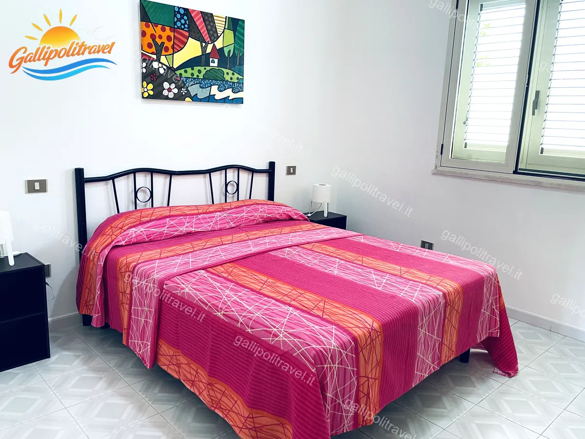 Chambre double aux tons roses du trois pièces Tamerici 03, Baia Verde