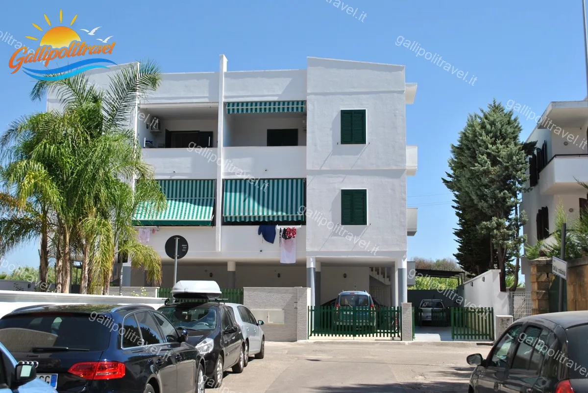 Facciata del Trilocale Girasole a Baia Verde Gallipoli con palme e cielo blu