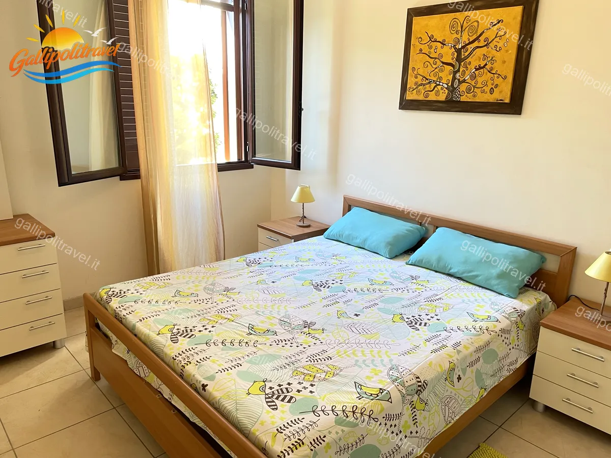 Double bedroom with turquoise cushions of the three-room apartment Yellow, Baia Verde