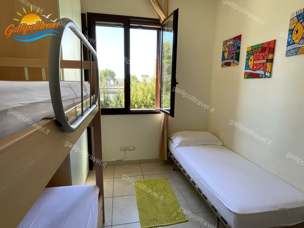 Bedroom with single beds and window of the three-room apartment Yellow, Baia Verde